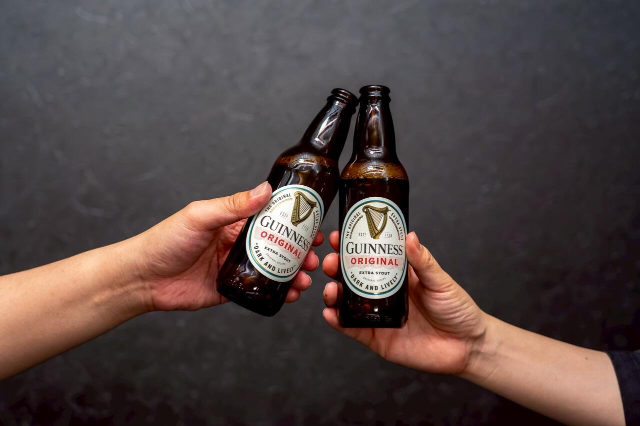 瓶ビールで乾杯する二人の手元